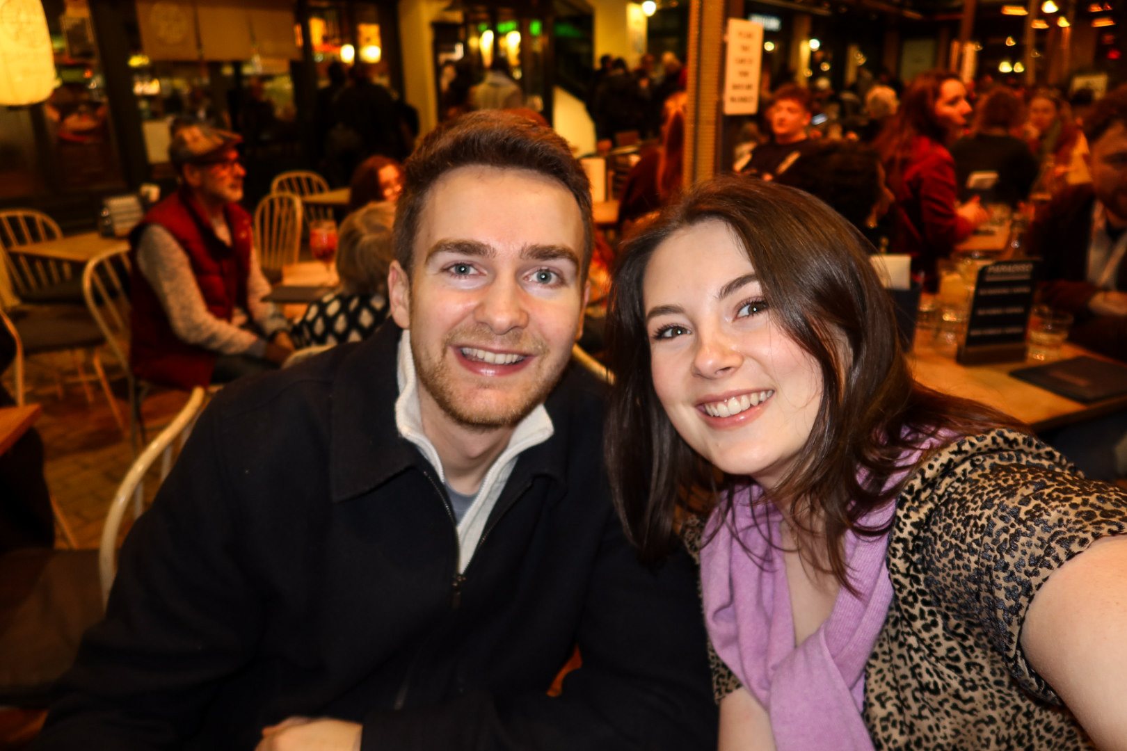 Ellie and Sam together in a warmly lit restaurant