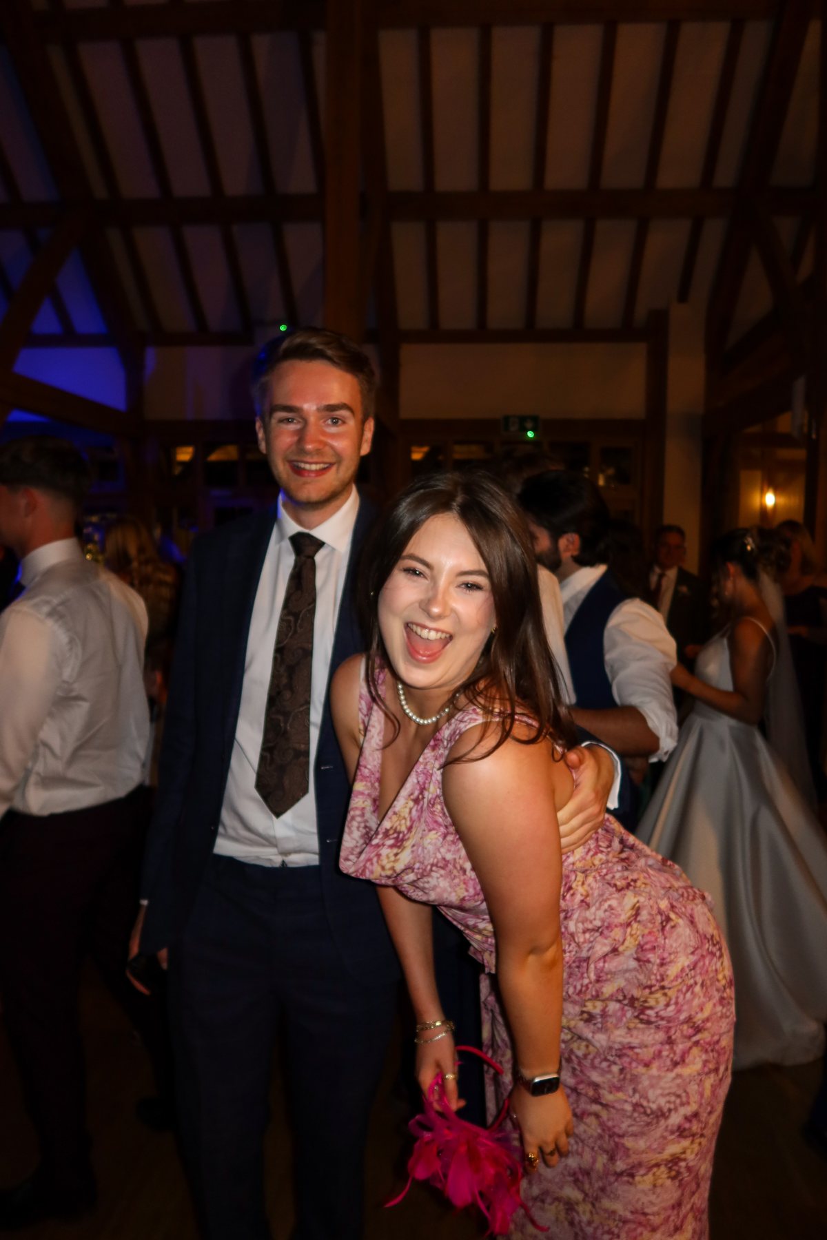 Ellie laughing with Sam at a party